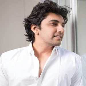 Parth Oza, in a white shirt, looking off to one side.